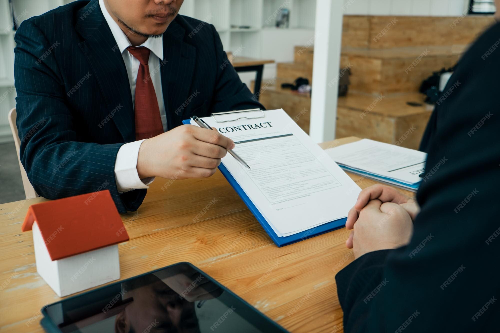 Business attorney reviewing a contract with a client to prevent and resolve breach of contract disputes