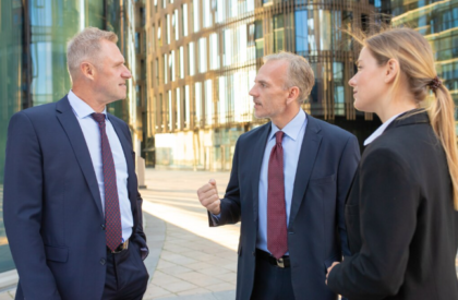 Business professionals discussing strategy outside modern office building