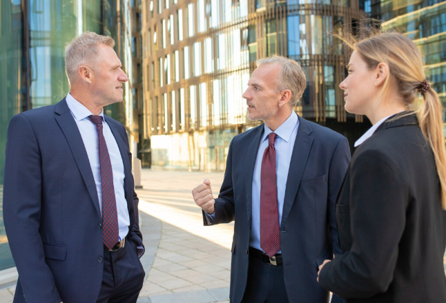 Business professionals discussing strategy outside modern office building