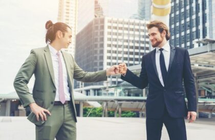 Two professional businessmen celebration high-five fist bump in urban city setting