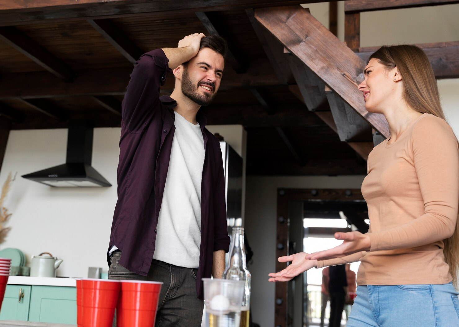 Frustrated couple having serious discussion during social gathering with friends at home