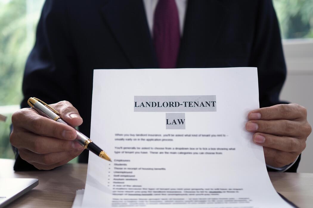 Attorney presenting a landlord-tenant law document while holding a pen